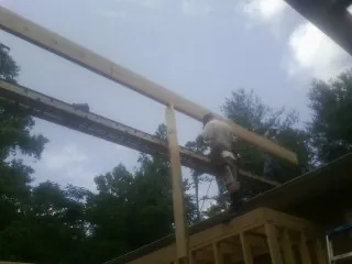 Carpenter setting a ridge beam over a new addition frame — Ice Dam Removal by Roofing Brothers in Camp Grove