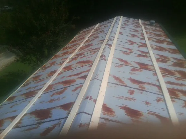 Rusted metal roof panels with new wood purlins before replacement — Storm Damage Roof Repair in Camp Grove by Roofing Brothers