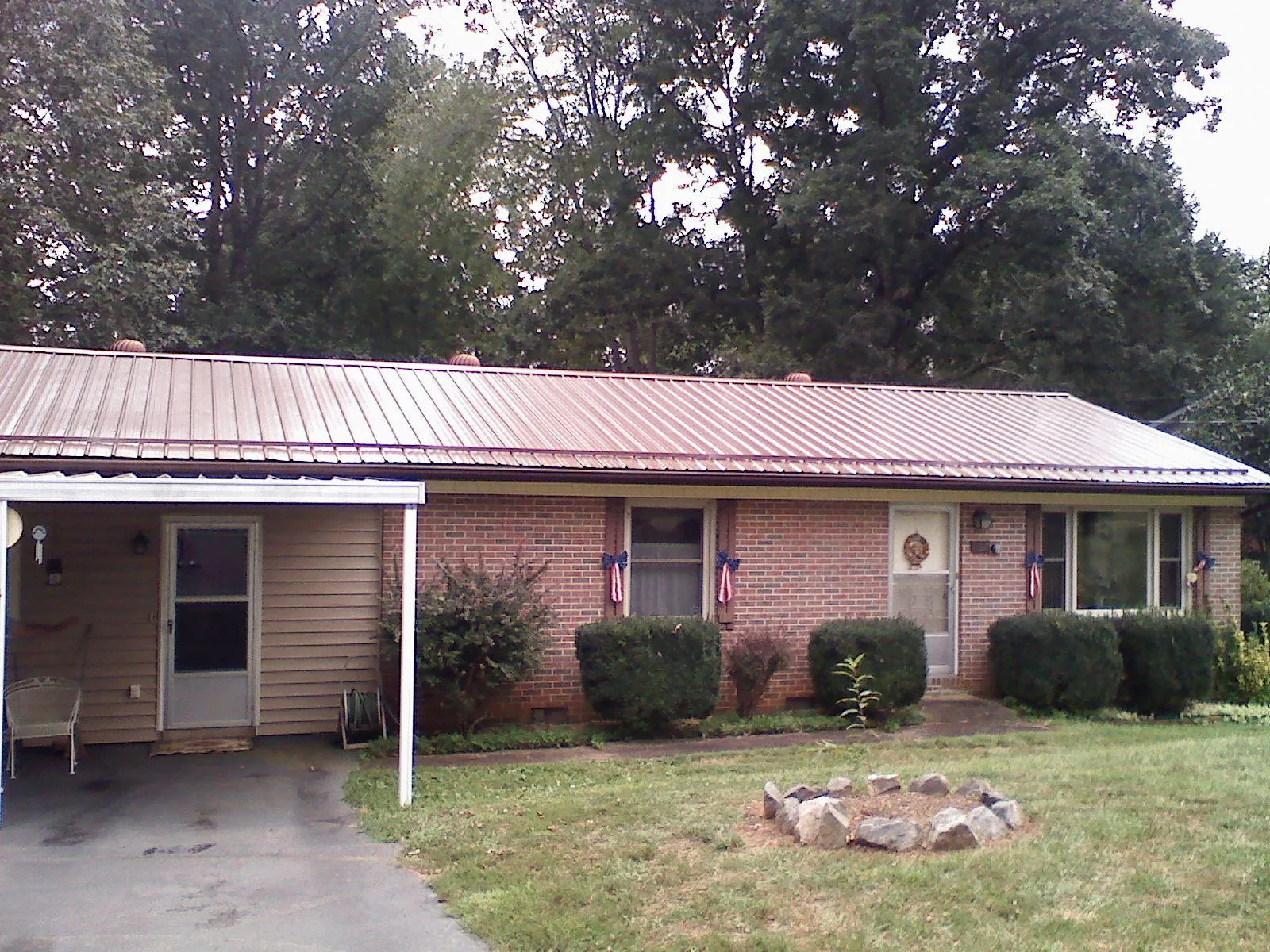 Bronze metal roof and carport on a brick ranch home — Roof Repair work by our crew in Camp Grove